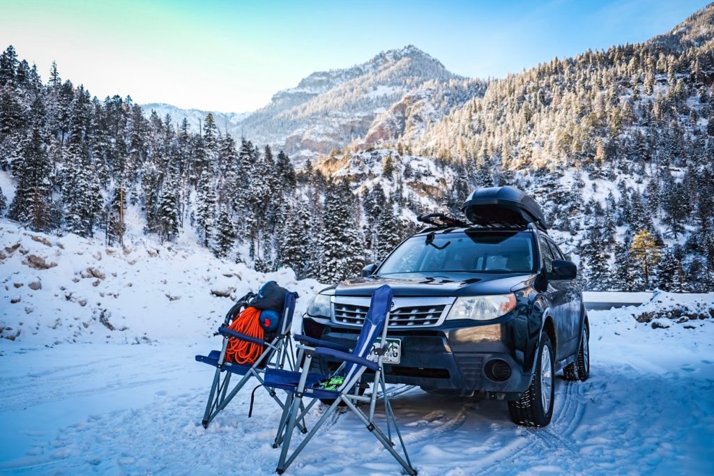 Two camp chairs are set up in front of a car parked near the Ouray Ice Park.