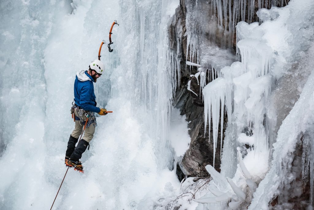 An ice climber stops to place a screw at the Ouray Ice Park.
